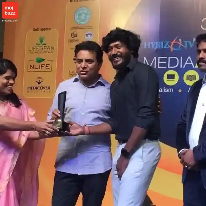 A man (Rj Surya) wearing black shirt accepting an award in an award function